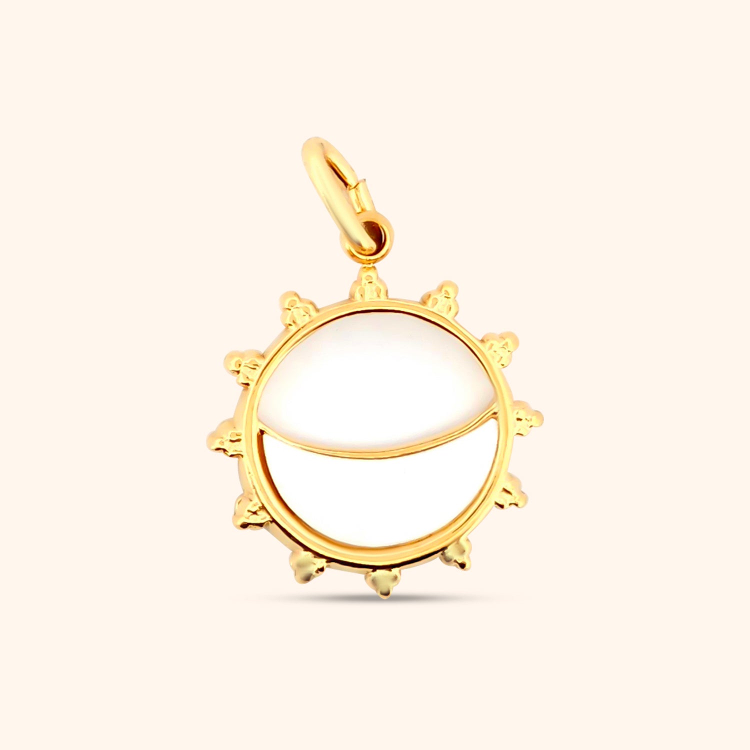 Close-up of the Solstice Sun Charm, a gold charm with a detailed sun design, featuring a mother-of-pearl center and radiating lines.